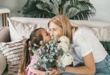 A little girl giving her mother flowers for Mother's Day